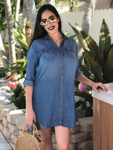 Blue thigh length, denim dress with gold buttons. Long sleeves that can be worn rolled up.