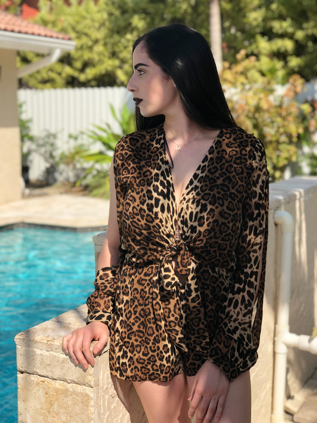 Leopard print romper with long open sleeves. Deep V neckline and ties in the front.